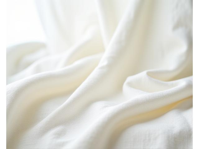 Una camisa de lino irlandés arrugada pero elegantemente desgarbada sobre una superficie de madera clara, con una luz natural realzando la textura de la tela.